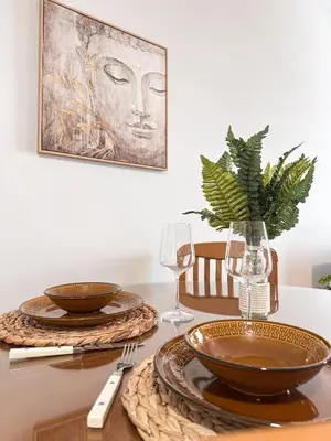 a table with two plates and a vase with a plant at Sea the City - Chic 2-BDR Escape with Spacious Living in Athens