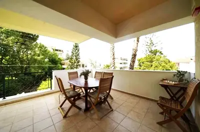 a patio with a table and chairs on a balcony at Voula Family Home in Athens