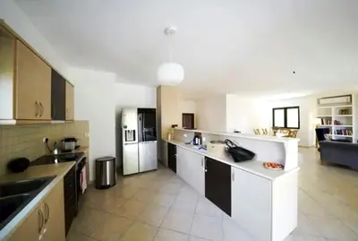 a large kitchen with white counters and a white refrigerator at Voula Family Home in Athens