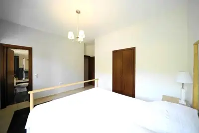 a bedroom with a bed and a chandelier at Voula Family Home in Athens