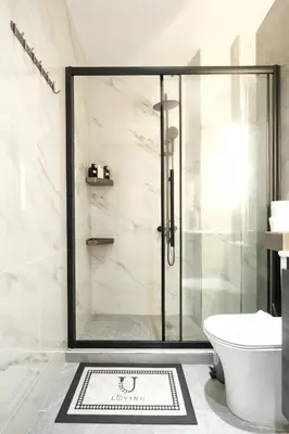 a bathroom with a shower and a toilet and a rug at Cozy Home With Cooking Near Tram in Piraeus