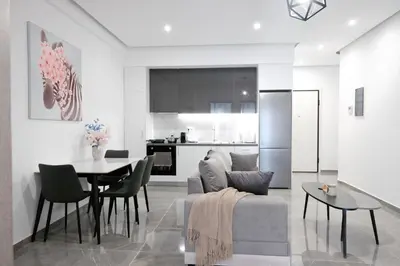 a kitchen and living room with a couch and a table at Cozy Home With Cooking Near Tram in Piraeus