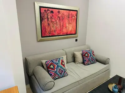 a couch in a living room with a painting on the wall at Port Brown Suite 1 in Piraeus
