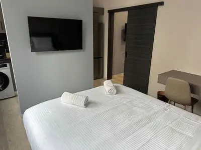 a white bed with two towels on top of it at Port Brown Suite 1 in Piraeus