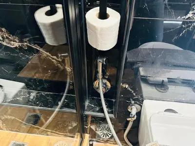 a bathroom with a toilet and two rolls of toilet paper at Port Brown Suite 1 in Piraeus