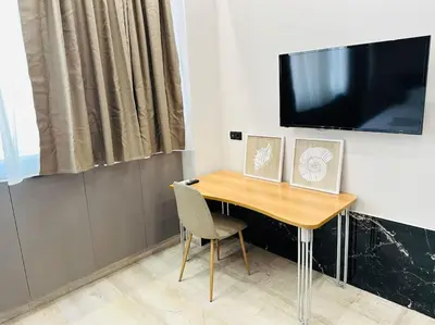 a wooden table with a television on a wall at Port Brown Suite 2 in Piraeus