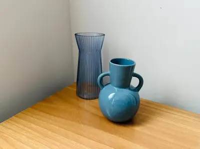 a blue vase and a glass on a table at Port Brown Suite 2 in Piraeus