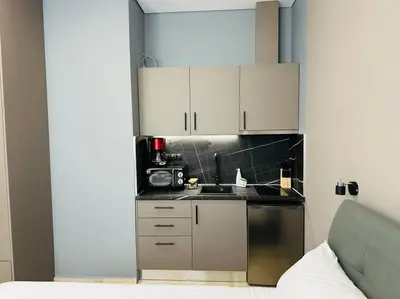 a kitchen with white cabinets and a sink at Port Brown Suite 2 in Piraeus