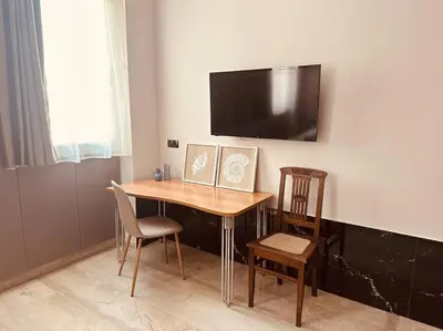 a dining room table with two chairs and a television on the wall at Port Brown Suite 2 in Piraeus