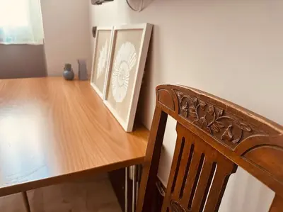 a wooden table with a wooden chair and two pictures at Port Brown Suite 2 in Piraeus
