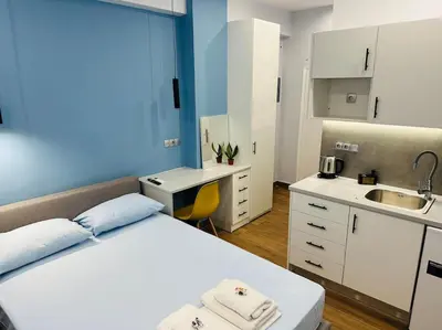 a bedroom with a bed and a desk and a sink at Blue Suite at Piraeus Port in Piraeus