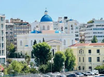 a large white building with blue domes in a city at Blue Suite at Piraeus Port in Piraeus