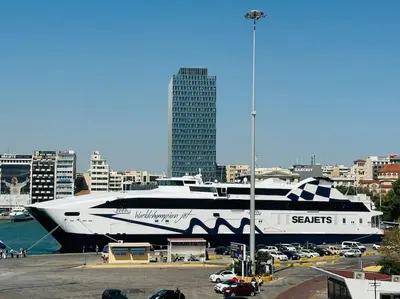 a large cruise ship is docked in a parking lot at Blue Suite at Piraeus Port in Piraeus