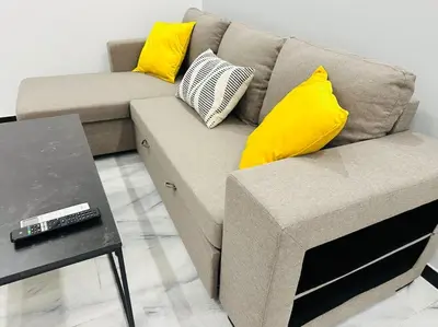 a couch with yellow pillows and a table in a living room at Grey Suite at Piraeus Port in Piraeus