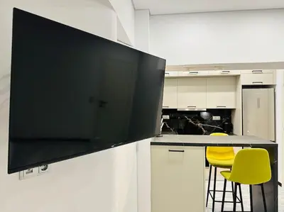 a kitchen with a large flat screen tv on a counter at Grey Suite at Piraeus Port in Piraeus