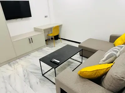 a living room with a couch and a tv at Grey Suite at Piraeus Port in Piraeus