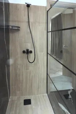 a shower with a glass door in a bathroom at Αthens Black & White Escape in Athens