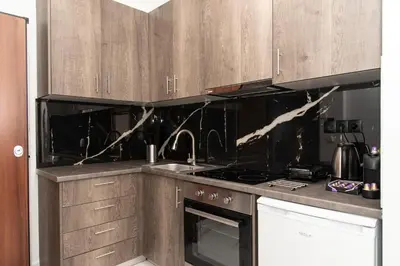 a kitchen with wooden cabinets and a stove top oven at Αthens Black & White Escape in Athens