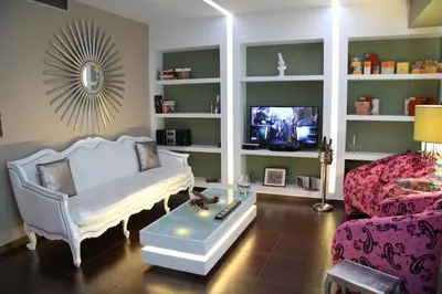 a living room with a couch and a tv at Andromeda Suites in Athens