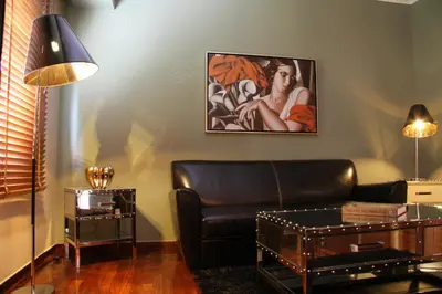 a living room with a leather couch and a table at Andromeda Suites in Athens