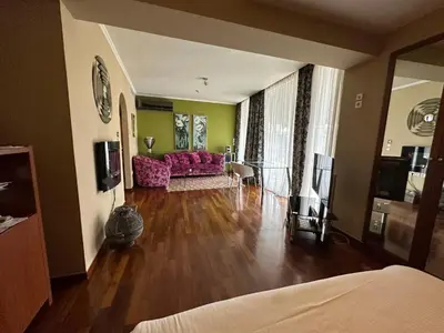 a living room with a pink couch and a table at Andromeda Suites in Athens