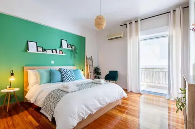 a bedroom with a large bed with a green wall at Casa Almera in Athens