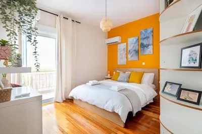 a bedroom with orange walls and a large bed at Casa Almera in Athens