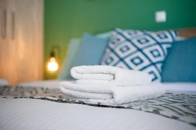 a pile of towels sitting on top of a bed at Casa Almera in Athens