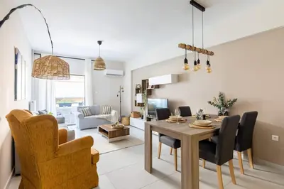 a dining room and living room with a table and chairs at Casa Almera in Athens
