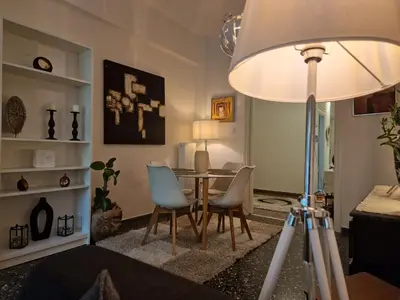 a room with a table and chairs and a lamp at Modern apartment in Neo Faliro in Piraeus