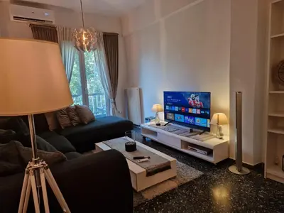 a living room with a couch and a flat screen tv at Modern apartment in Neo Faliro in Piraeus