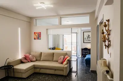 a living room with a couch and a window at Stylish and cozy flat at pagrati in Athens