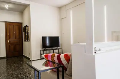 a living room with a couch and a tv at Stylish and cozy flat at pagrati in Athens
