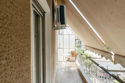 a balcony with a chair and a window at Stylish and cozy flat at pagrati in Athens