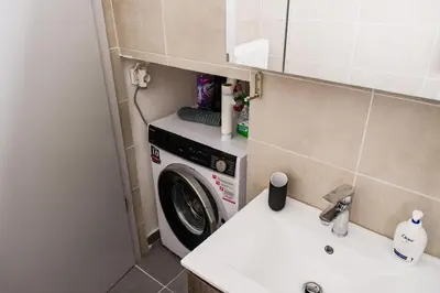 a washing machine in a small bathroom with a sink at Stylish and cozy flat at pagrati in Athens
