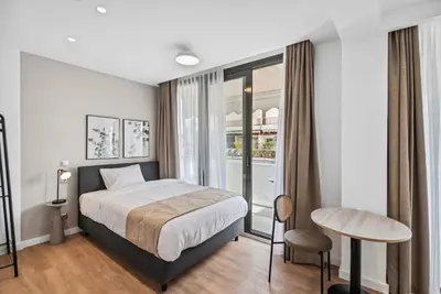 a hotel room with a bed and a window at Limehome Piraeus Olive in Piraeus
