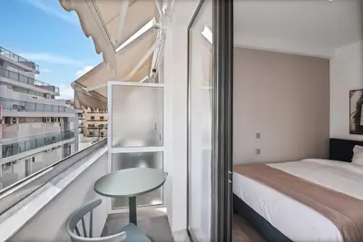 a bedroom with a bed and a table and a window at Limehome Piraeus Olive in Piraeus