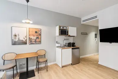 a kitchen and living room with a table and chairs at Limehome Piraeus Olive in Piraeus
