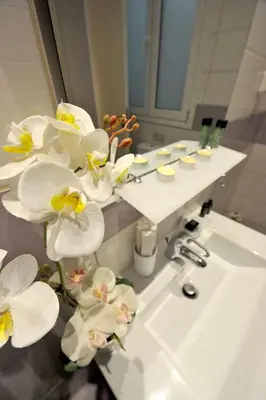 a bathroom with a sink with white flowers on it at My Athens House in Athens