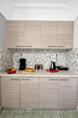a kitchen with wooden cabinets and a counter top at My Athens House in Athens