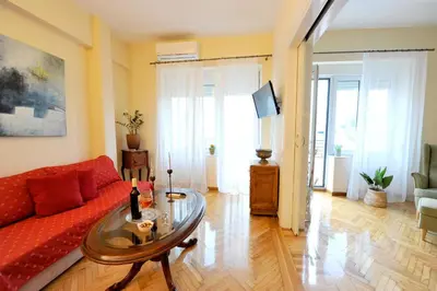 a living room with a red couch and a glass table at My Athens House in Athens