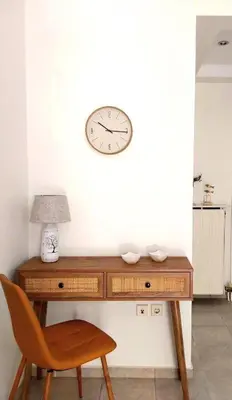 a desk with a chair and a clock on a wall at RELAX & RECHARGE apartment 1 in Athens