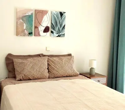 a bedroom with a bed with three paintings on the wall at RELAX & RECHARGE apartment 1 in Athens