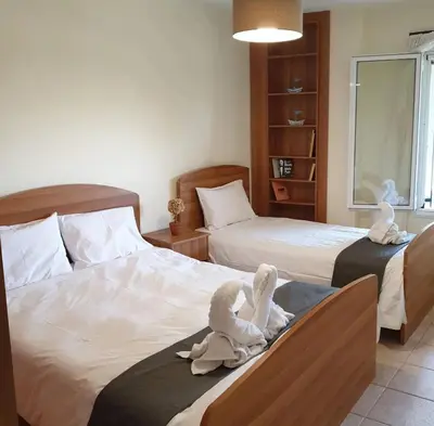 two swans sitting on two beds in a bedroom at Betty s House Porto Rafti in Porto Rafti