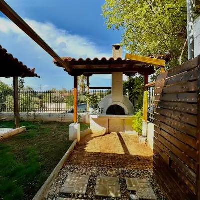 a patio with a pizza oven in a yard at Betty s House Porto Rafti in Porto Rafti