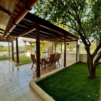 a patio with a table and chairs and a tree at Betty s House Porto Rafti in Porto Rafti