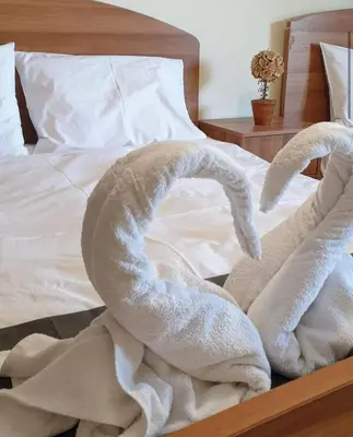 a bed with two white towels on it at Betty s House Porto Rafti in Porto Rafti