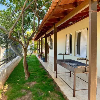 a porch of a house with a bench next to a tree at Betty s House Porto Rafti in Porto Rafti