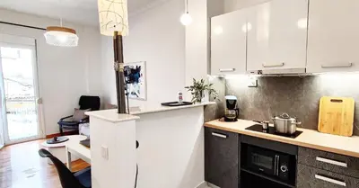 a kitchen with white cabinets and a counter top at Διαμέρισμα στο Θησείο in Athens