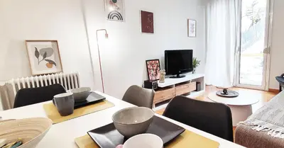 a living room with a table and chairs and a television at Διαμέρισμα στο Θησείο in Athens